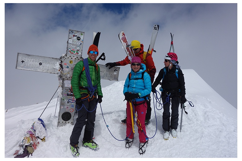 característica estampa de esquiadores de montaña alrededor de la cruz que se encuentra en la cima del Aneto