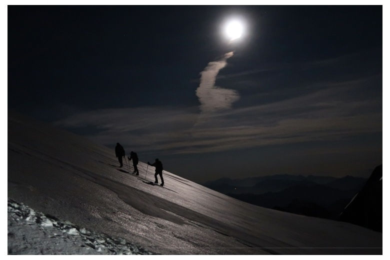 grupo de tres alpinistas subiendo al mont blanc por la noche