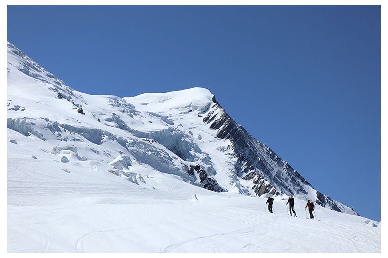 group of touring skiers skinning up the mont blanc on blue sky day