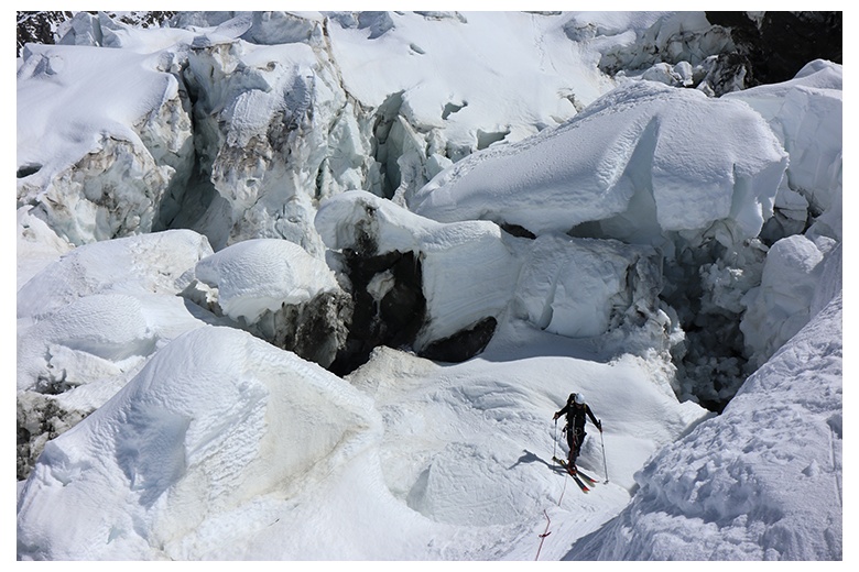 skieur de randonnée qui traverse entre les inmenses crevasses pendant l'ascension au mont blanc