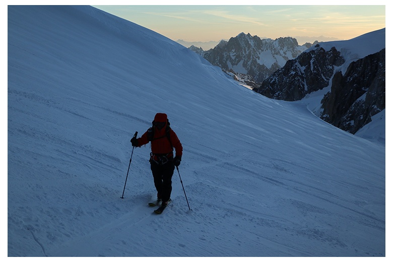 esquiador de montaña en ladera avanzando hacia lo más alto del mont blanc en un momento de la ascensión muy pronto por la mañana