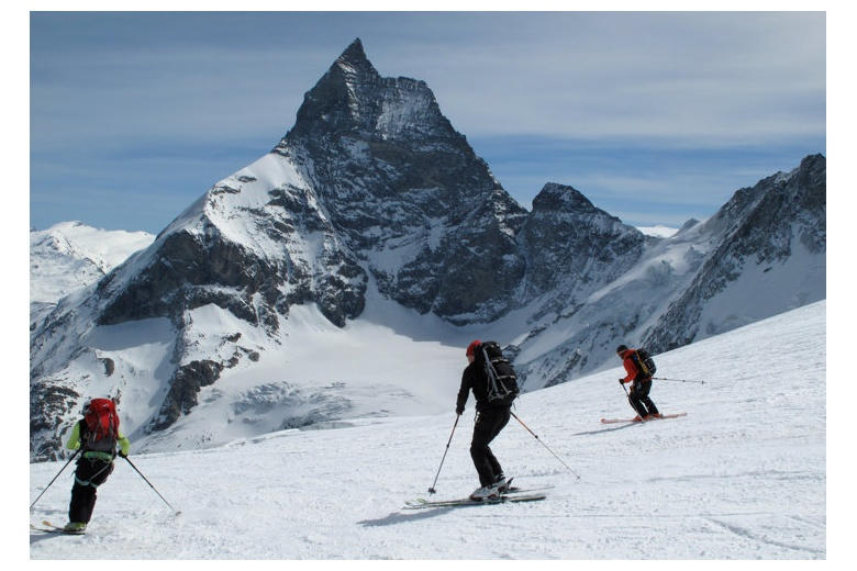 grupo de esquiadores bajando a Zermatt con el cervino o Matterhorn al fondo