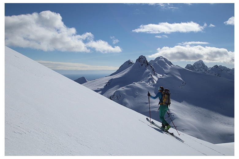 esquiadora de montaña ascendiendo en las islas lofoten con un día insuperable equiparable a las impresionantes vistas de mar y cimas