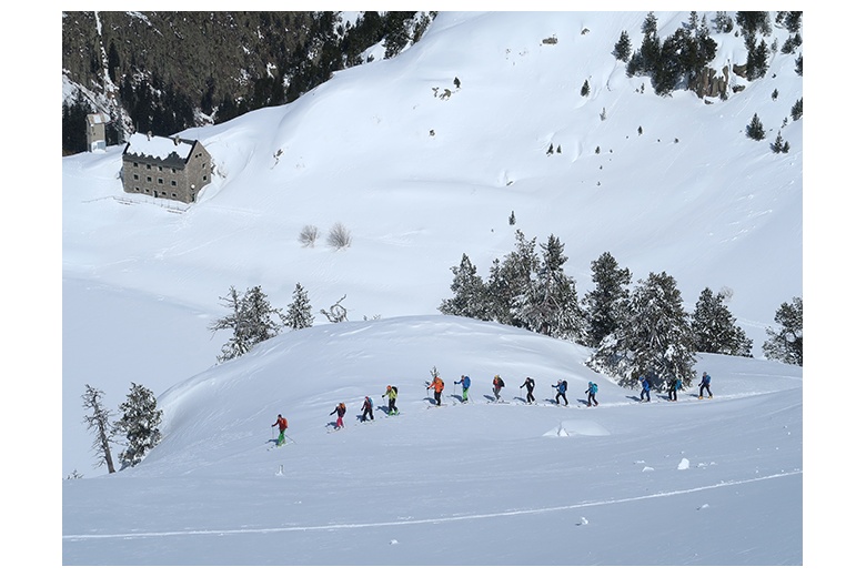 groupe de skieurs qui montent par Valarties et qui laissent le refuge de restanca derriére