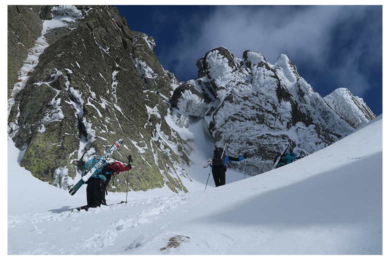 two mountaineering skiers getting past the bretxa de pauss at serra de tumeneia