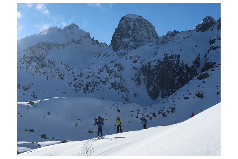 skiers on their way down to ventosa i calvell hut with superb view of pa de sucre at the back