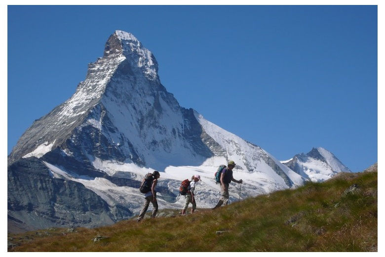 hikers on an up-slope with the unique matterhorn on the background