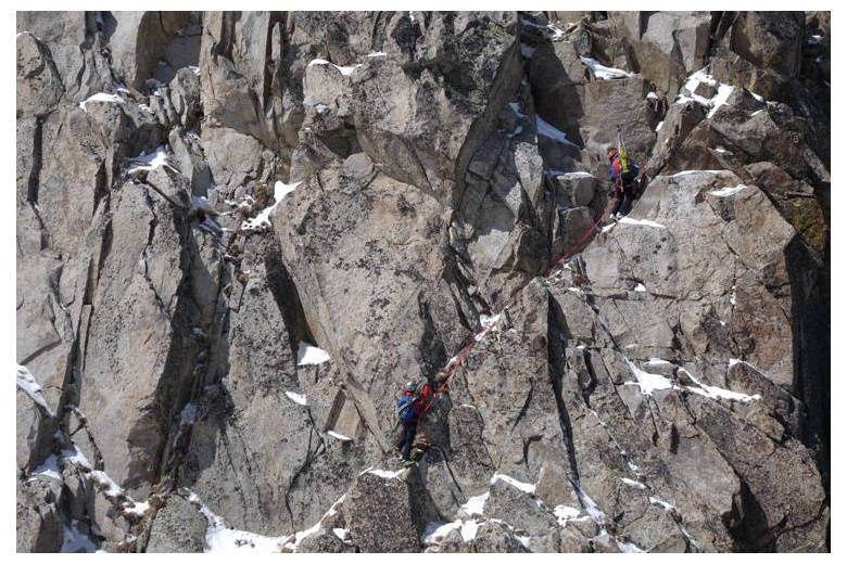 cordée de alpinistes qui progressent à travers une maginifique montée de roche et neige