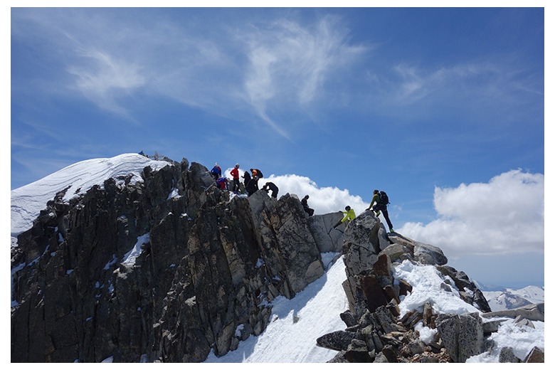 grupo de esquiadores de bajada tras cima en el famoso paso de mahoma
