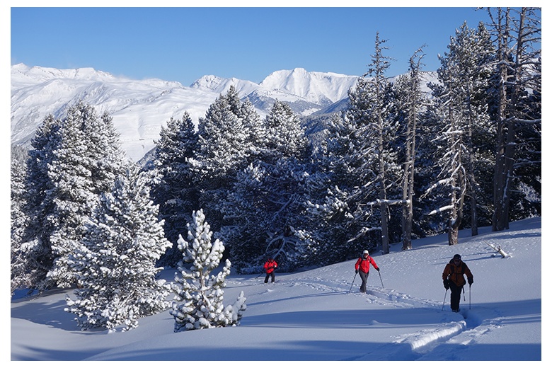 grupo de esquiadores de travesía ascendiendo al tuc de la salana en precioso día con huella abierta