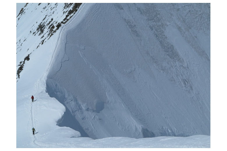 two people climbing along an impressive snow ridge