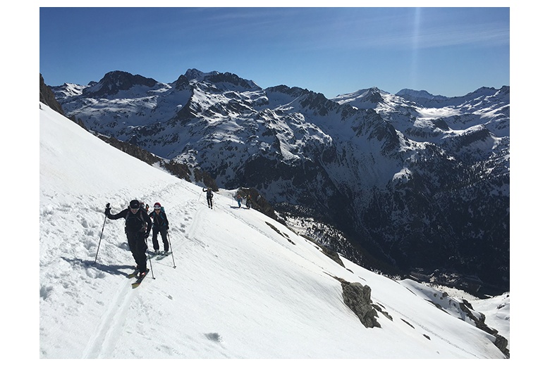 grupo de esquiadores de montaña de camino hacia la cima del garmo negro en día espectacular de cielo azul. Vista del Pico Batanes y Vignemale al fondo