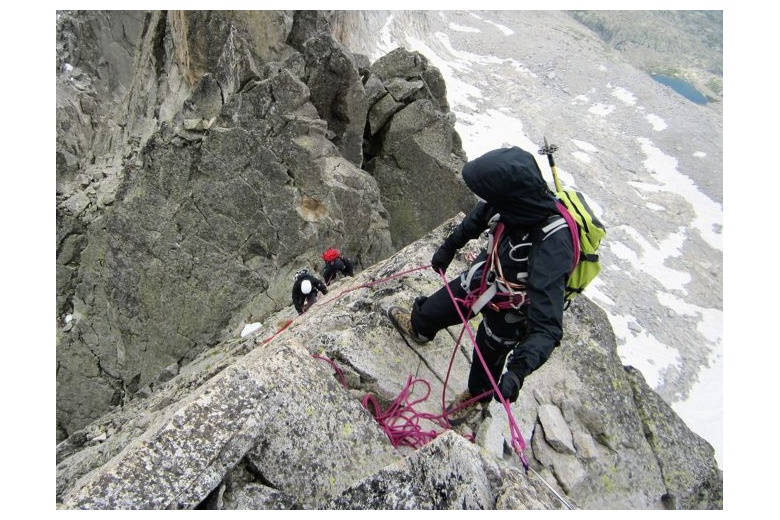 alpinistes qui progressent en protection par le guide de haute montagne dans la crête de salnques