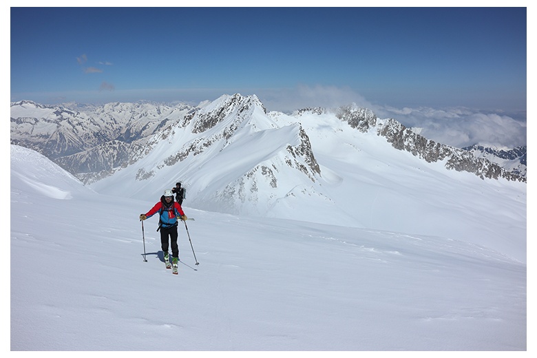 esquiadores de montaña tras superar el collado de coronas de camino hacia la cima del aneto con vista de los portillones  a sus espaldas