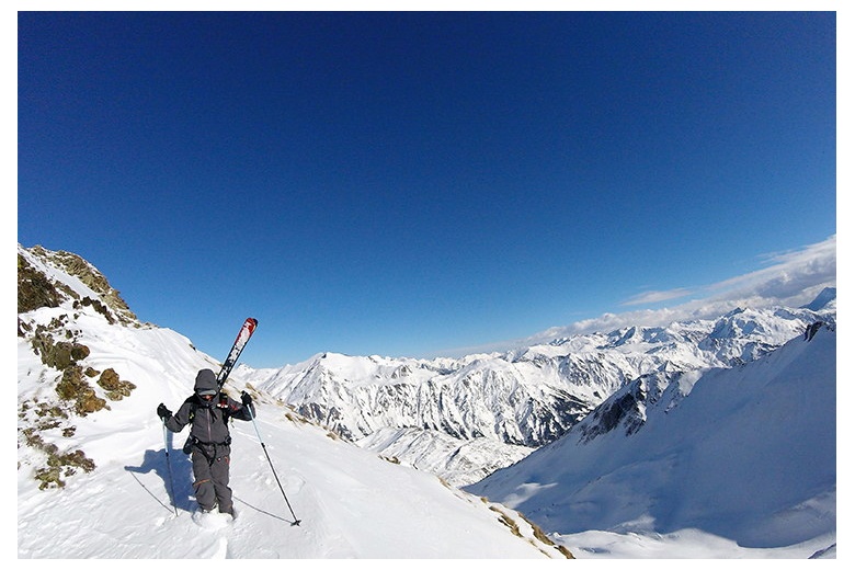 skieur qui descent une petite colline à l'arête du sommet du tuc deth pincèla, magnifique vue de la vallée derrière