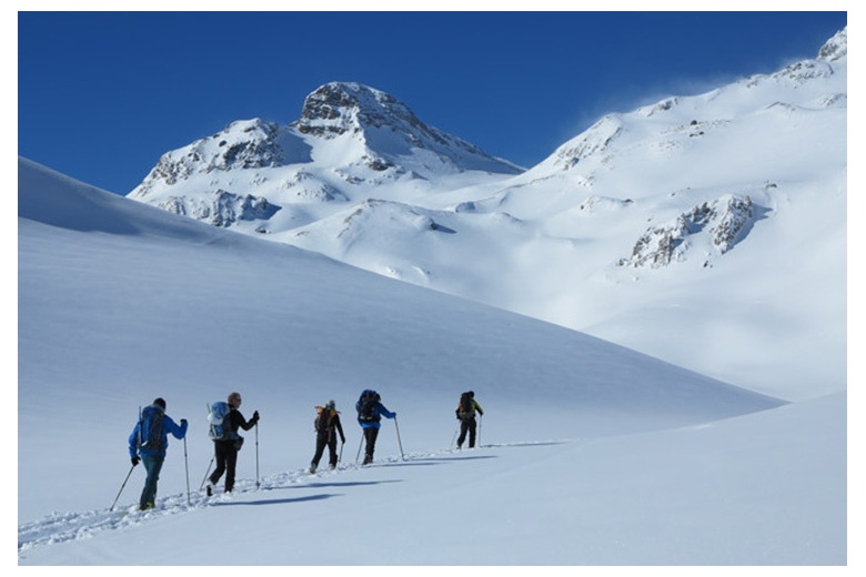 skieurs qui montent sans traces avec formidable ciel bleu
